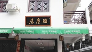 A hotel entrance with a green awning, a sign with Chinese characters, and a traditional architectural style. - Heyang Bichenju (Hengyang)