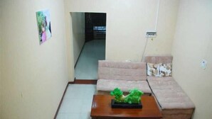 A living room with a sofa, a coffee table with a plant, and a picture on the wall. - Heyang Bichenju (Hengyang)