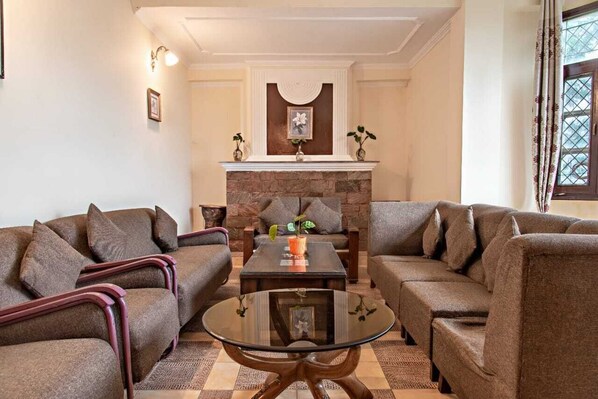 Una sala de estar con dos sofás, una mesita de centro y una chimenea.