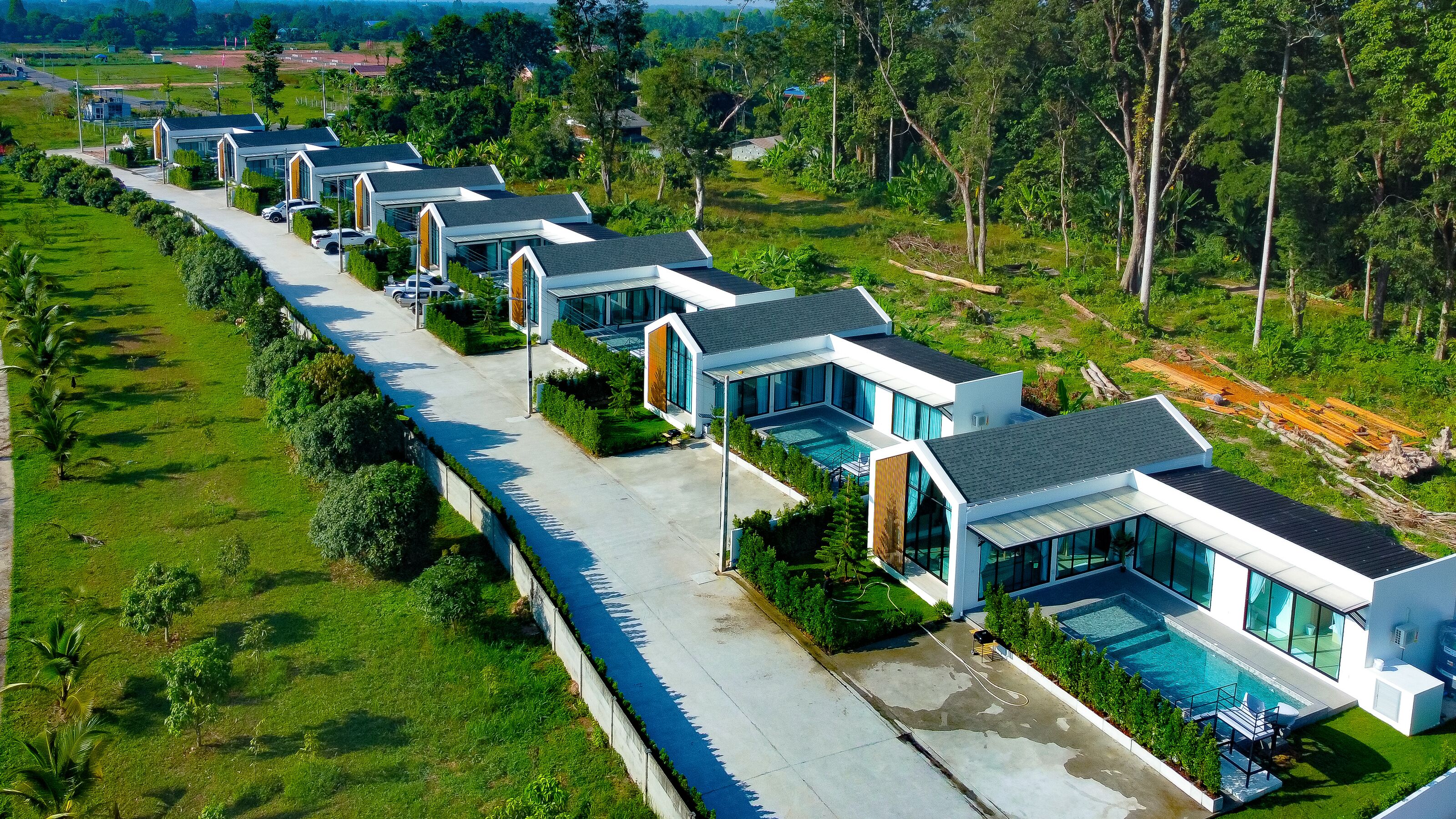 A row of modern, single-story houses with large windows and a swimming pool.