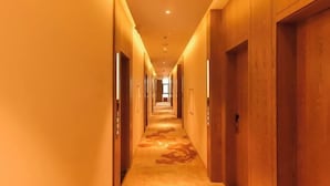 A long, narrow hotel corridor with wooden doors on both sides and a carpeted floor. - James Joyce Coffetel (Beijing Happy Valley Fatou Metro Station) (Beijing)