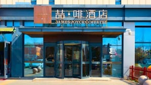 The exterior of James Joyce Coffee Shop with a glass entrance and signage in both English and Chinese. - James Joyce Coffetel (Beijing Happy Valley Fatou Metro Station) (Beijing)