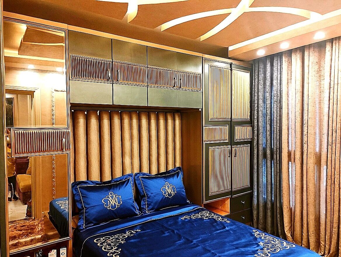 Een slaapkamer met een groot bed, een kast en een spiegel.