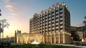 A modern hotel with a prominent entrance, multiple floors, and a well-lit facade. - Xinghua Grand Hotel (Xinghua)