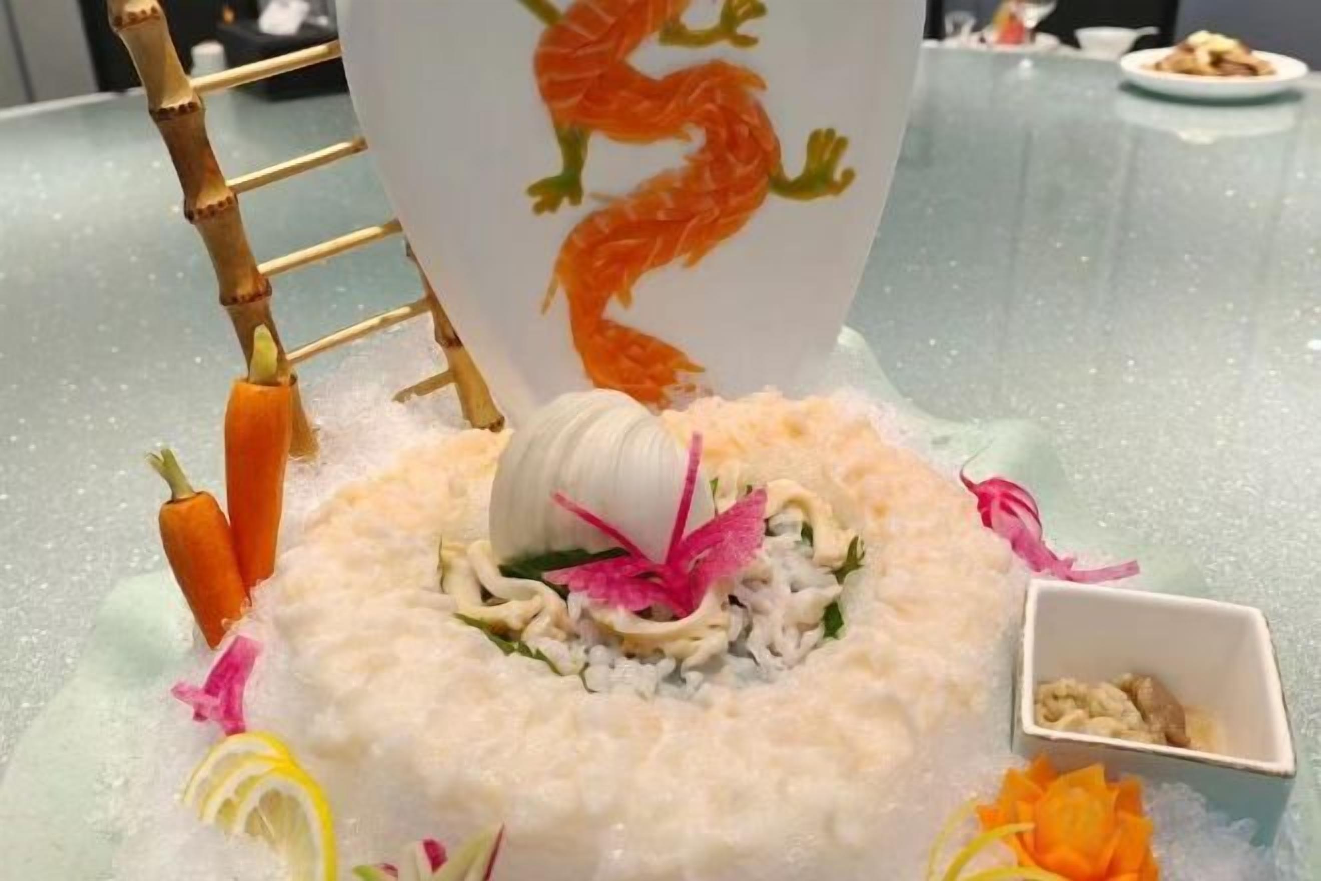 Una mesa con un centro decorativo que presenta un diseño de dragón, rodeada de diferentes adornos y un pequeño plato.