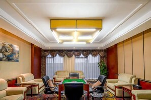 A conference room with a pool table, leather chairs, and a large chandelier. - Xinghua Grand Hotel (Xinghua)