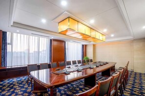 A conference room with a long table, chairs, and a ceiling light fixture. - Xinghua Grand Hotel (Xinghua)
