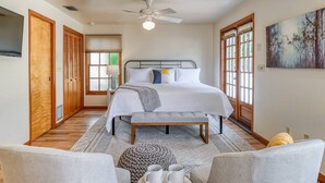 Une chambre à coucher avec un lit, une table de chevet et un tableau accroché au mur.