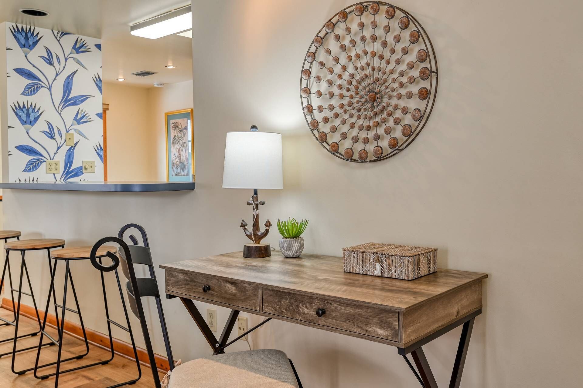 A dining area with a wooden table, chairs, a lamp, and decorative wall art.