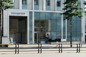 A modern building with a 'Mangrove Coffee & Bar' sign, large glass windows, and a visible entrance.