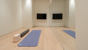 A spacious room with a wooden floor, two blue yoga mats, a wooden block, and a textured mat. - Mangrove Dongdaemun - Hostel (Seoul)