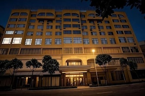 Un hotel de varios pisos con fachada simétrica, ventanas amplias y una entrada central.