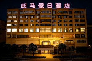 Un edificio de hotel de varios pisos con señalización iluminada en la parte superior.