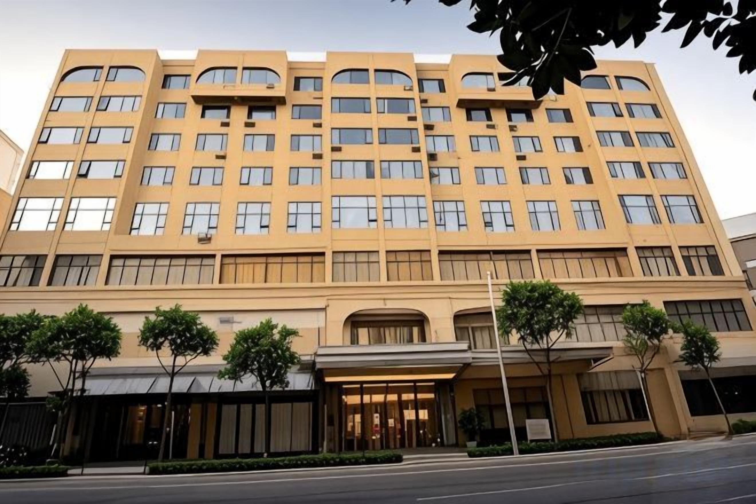 A multi-story hotel with a symmetrical facade, large windows, and a central entrance.