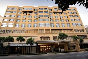 A multi-story hotel with a symmetrical facade, large windows, and a central entrance. - prosperous horse hotel (Kunming)