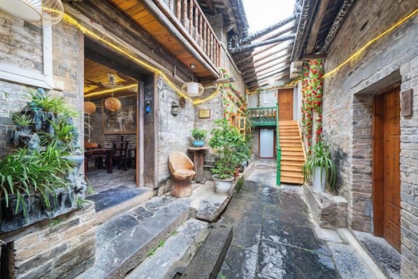 A narrow alleyway with traditional architecture, stone steps, and potted plants. - By Chance Bar&Inn (Zhaoping)