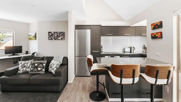 A modern apartment with a living area, kitchen, and dining space.