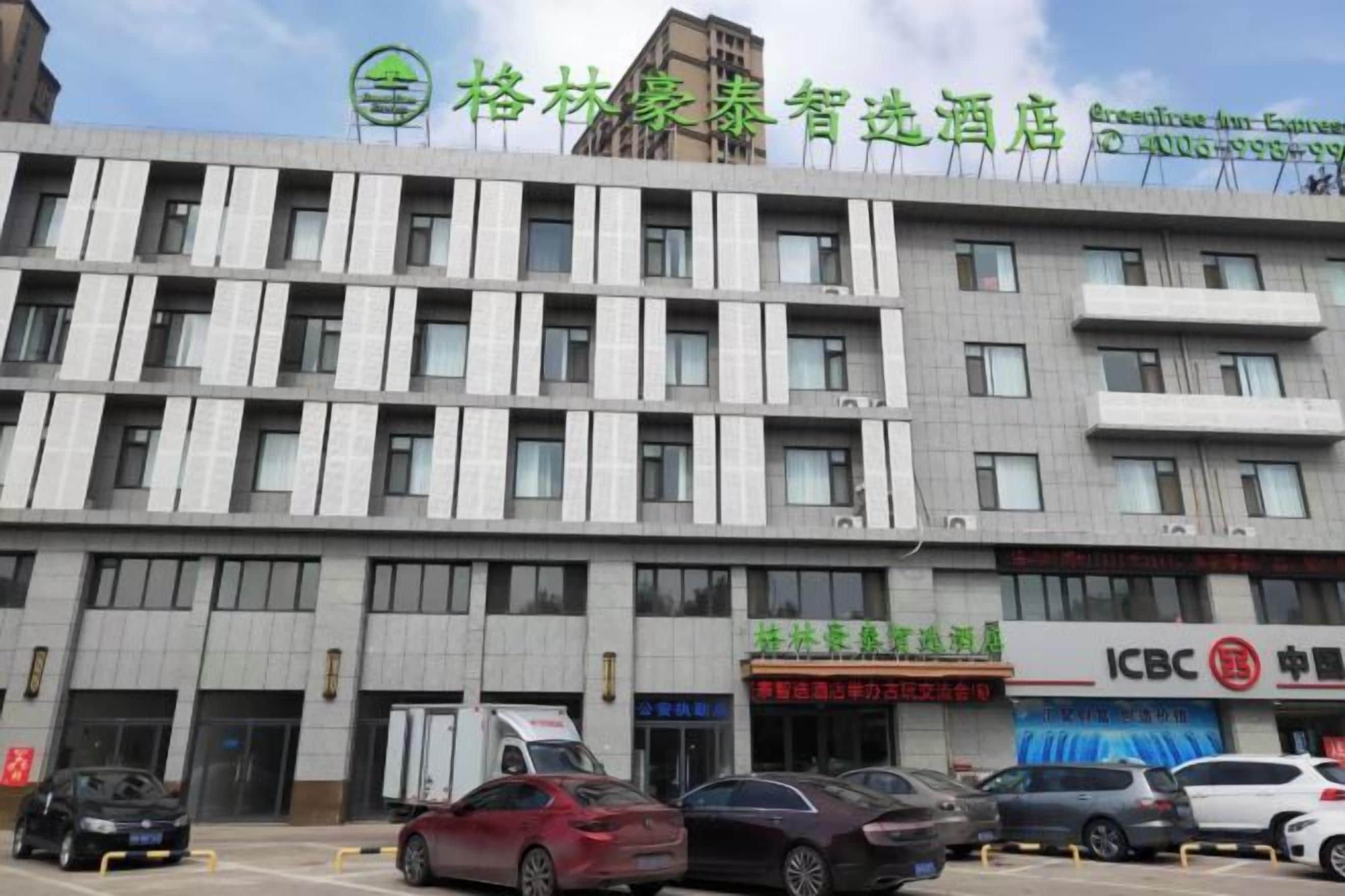 A multi-story hotel with a modern facade, featuring a series of windows and a prominent signage at the top.