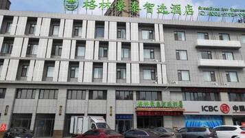 A multi-story hotel with a modern facade, featuring a series of windows and a prominent signage at the top.