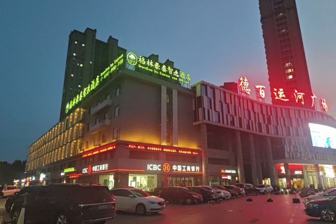 A multi-story building with signage for ICBC and a large digital display.