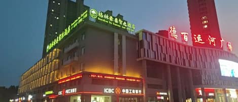 A multi-story building with signage for ICBC and a large digital display.