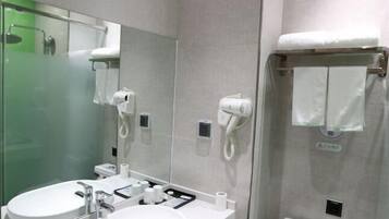 A modern bathroom with two sinks, a large mirror, and a glass-enclosed shower.