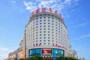 Ein mehrstöckiges Hotel mit einer gewölbten Fassade, großen Fenstern und Beschilderung in einer Fremdsprache.