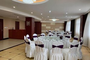 A banquet hall with round tables set for a formal event, equipped with glassware and white tablecloths. - Dihao Hotel (Wenshan City)