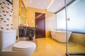 A modern bathroom with a toilet, a vanity with a marble countertop, a bathtub, and a large mirror. - Dihao Hotel (Wenshan City)