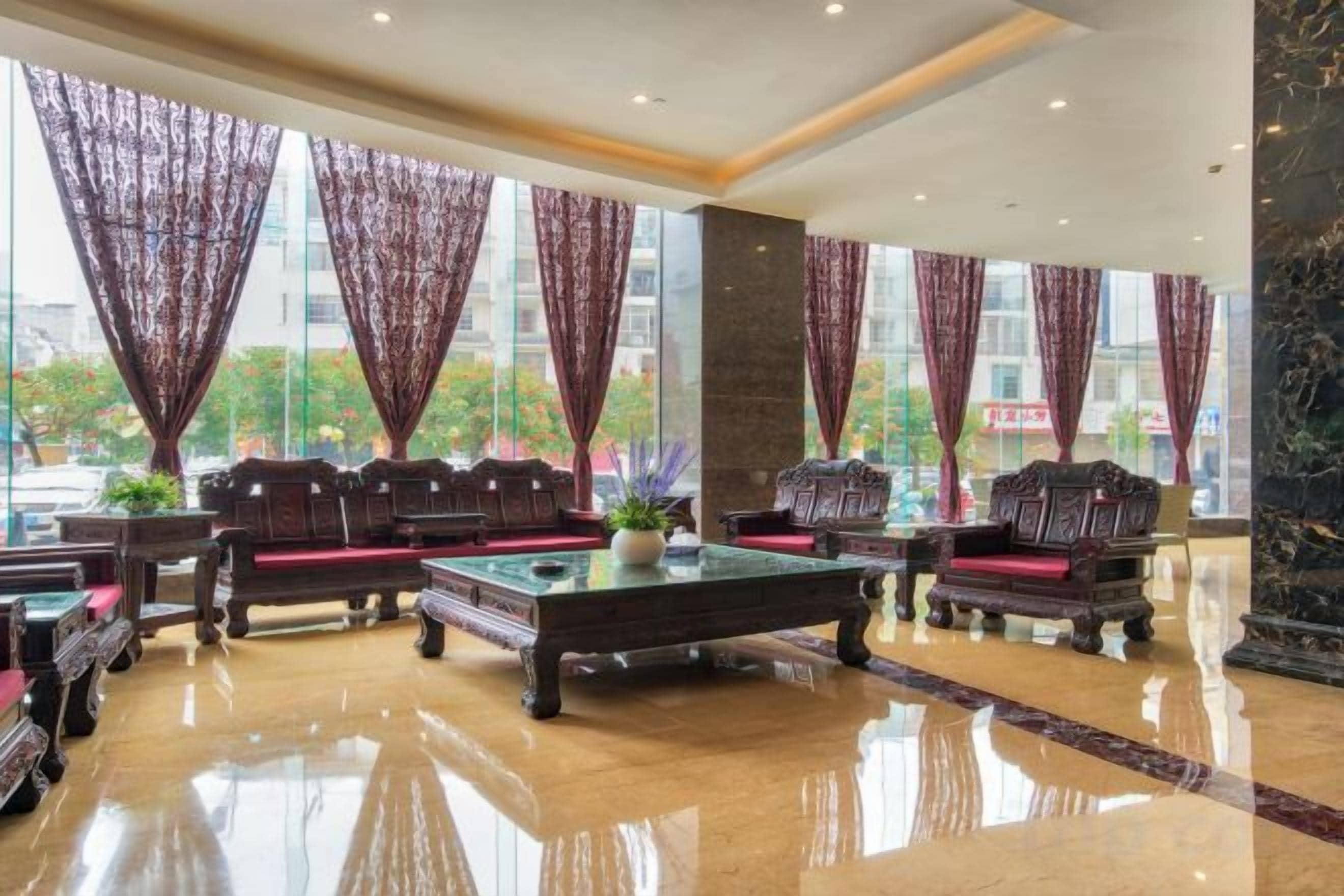 A lobby with a billiards table, seating area, and large windows.