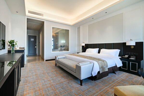 A modern hotel room with a large bed, a bedside table, a desk, and a view of the bathroom. - President Hotel Guangzhou Changlong (Guangzhou)