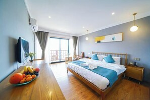 Habitación de hotel con cama, mesita de noche y frutero sobre la mesa.