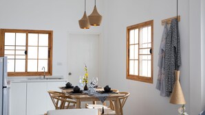 Un espace repas avec une table en bois, des chaises et des lampes suspendues.
