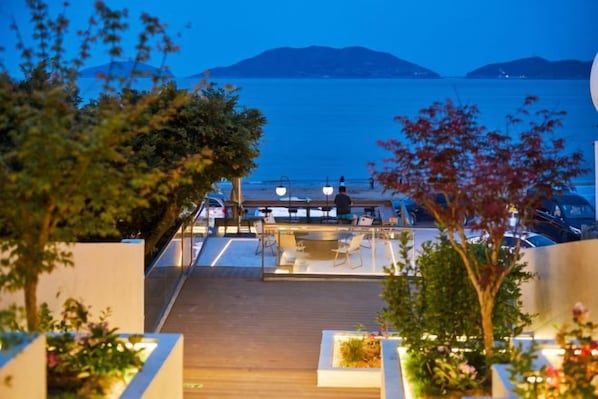 A terrace with a view of the sea, wooden deck, and outdoor seating. - Otter Home (Zhoushan)