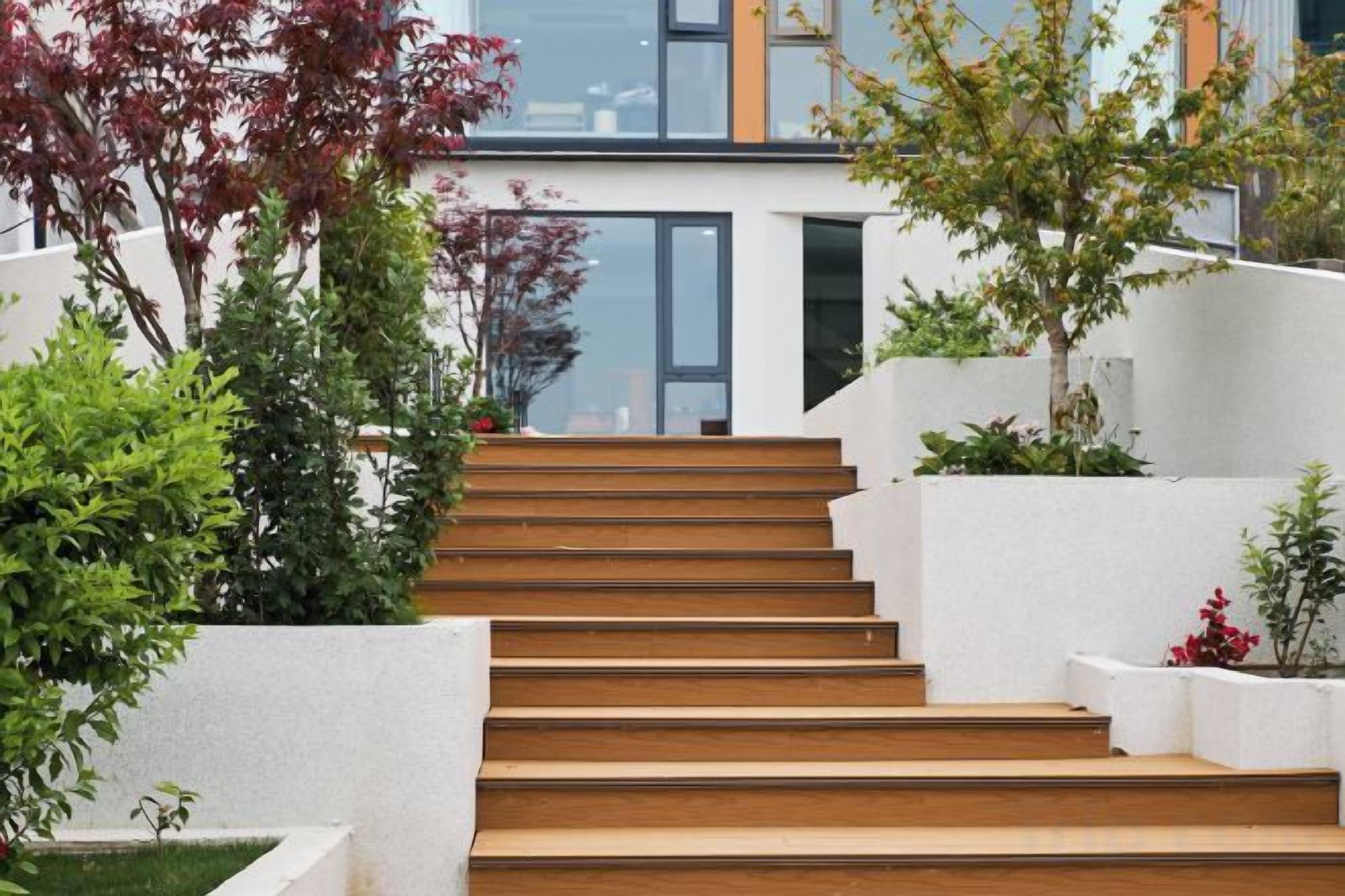 A staircase leading to a modern building with white walls and wooden steps.