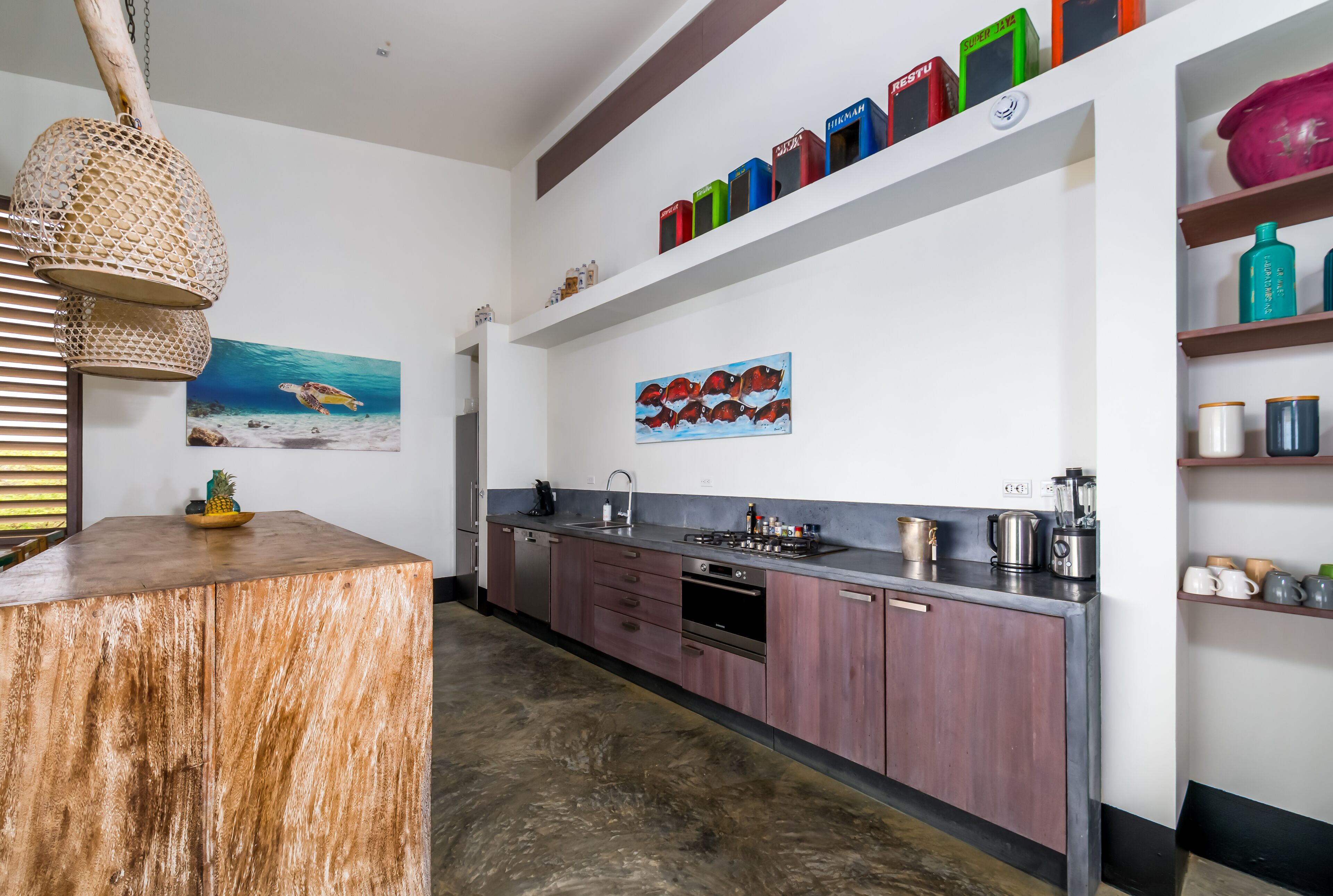 A modern kitchen with wooden cabinets, a central island, and a hanging light fixture.