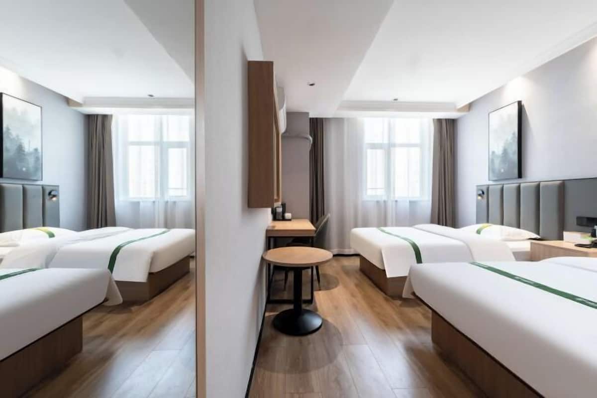 Habitació d'hotel amb dos llits, un escriptori i una cadira.
