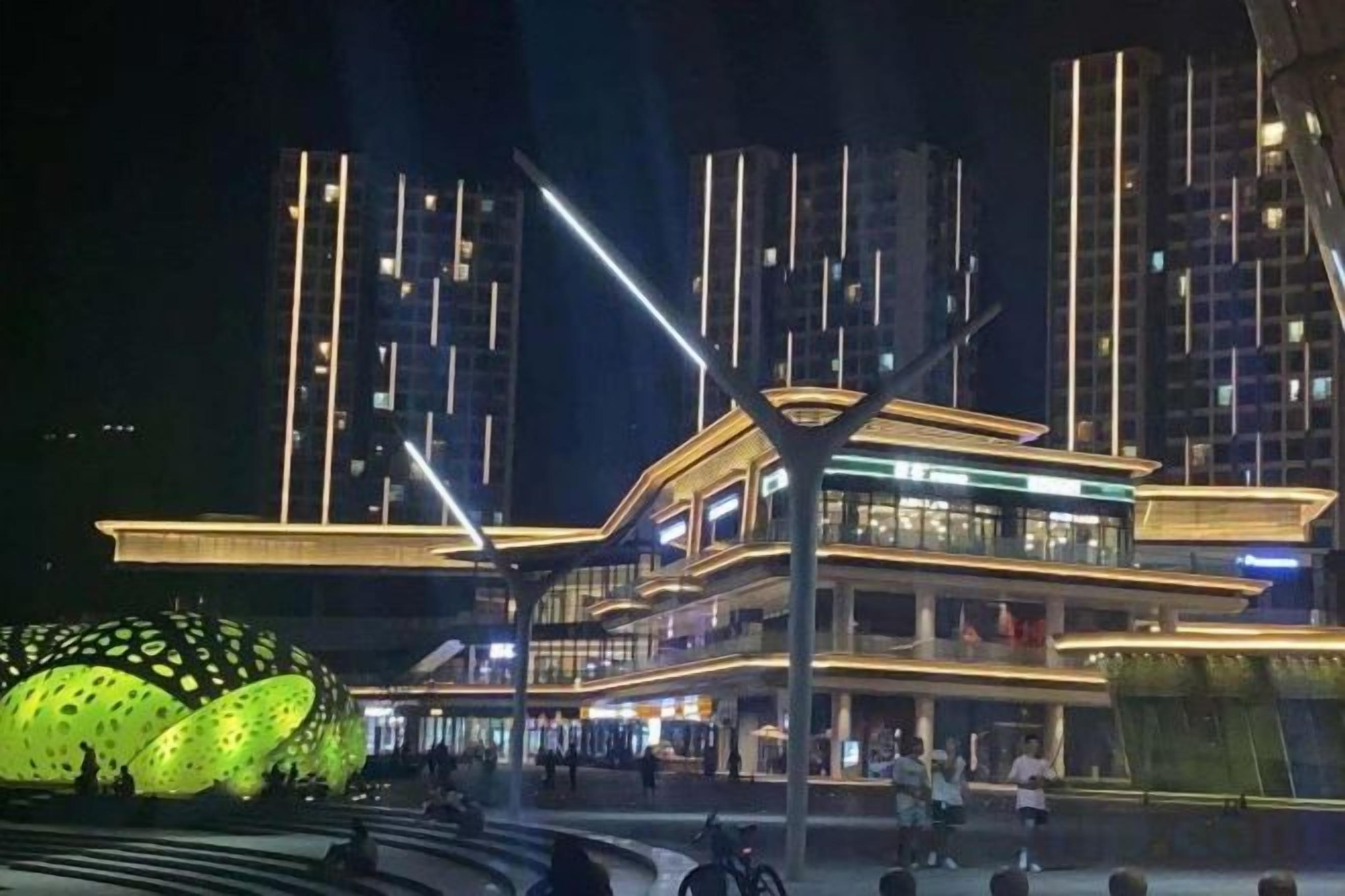 Un edificio moderno con estructura de varios niveles, iluminado con luz artificial.