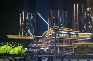 Um edifício moderno com estrutura em vários níveis, iluminado por luz artificial.