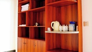 Un armario de madera con varios estantes, algunos con toallas blancas dobladas.