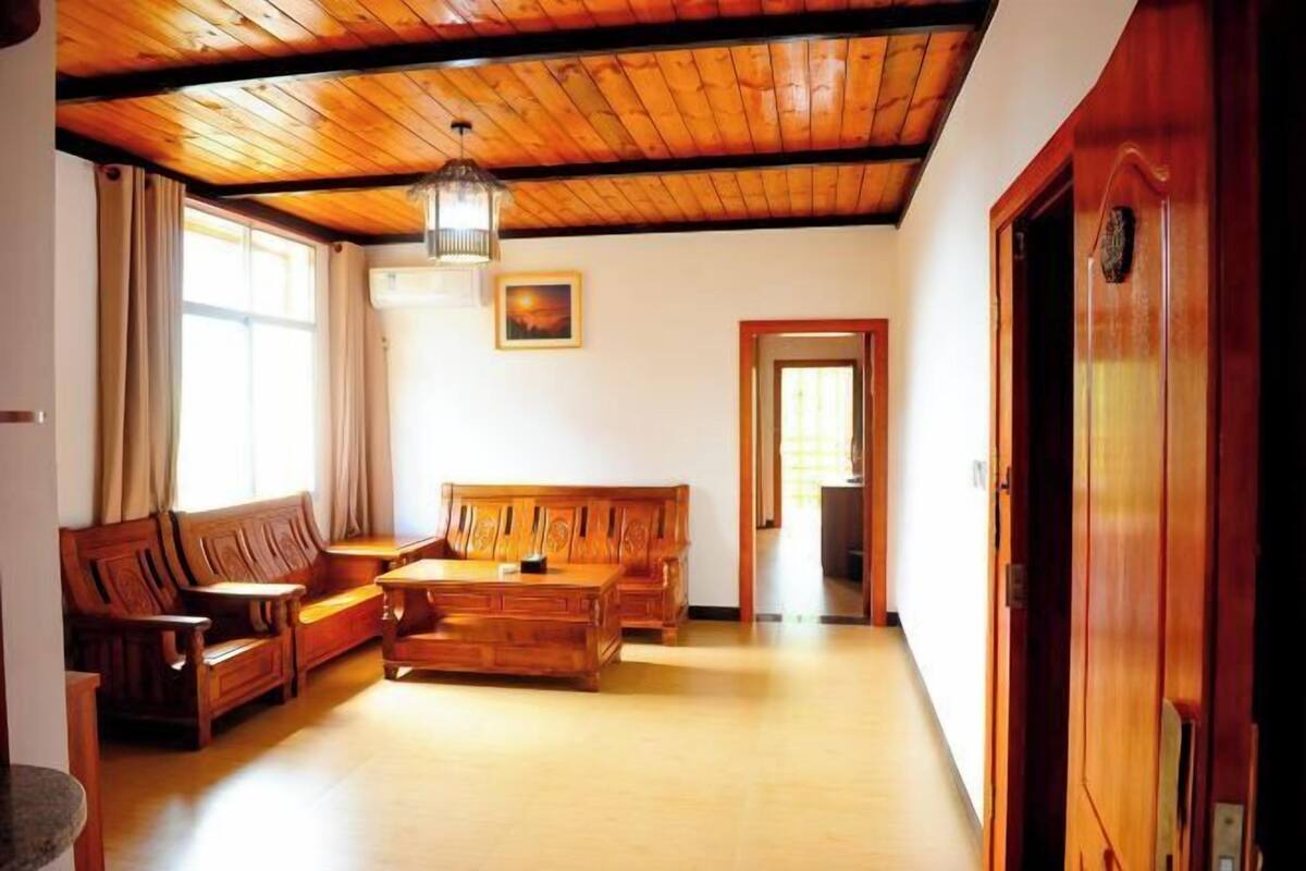 A room with wooden furniture, a ceiling fan, and a door.