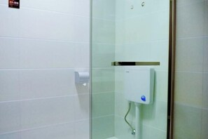 A bathroom with white tiles, a glass shower enclosure, and a hand dryer. - Jinying Shanzhuang Hotel (Hengshan County)