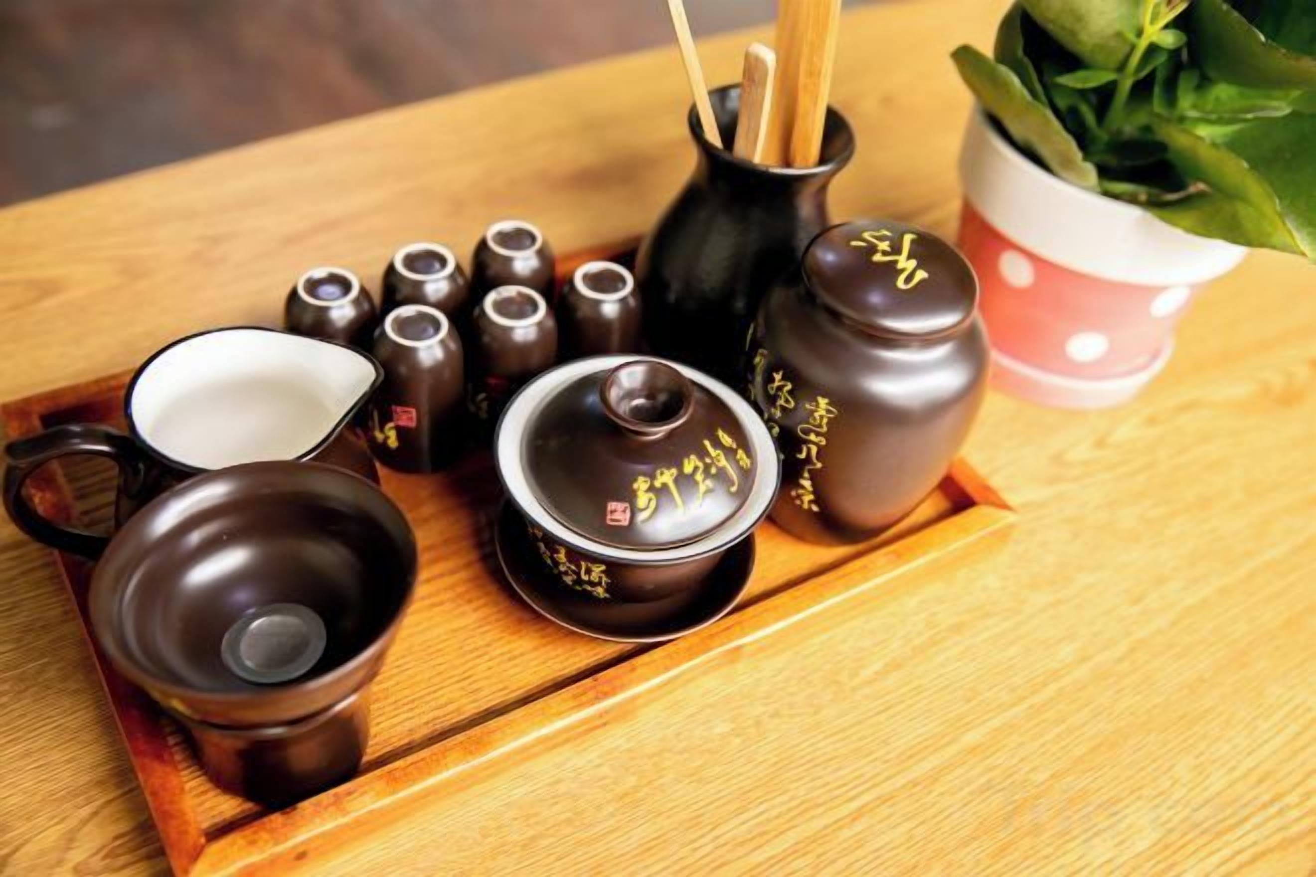 A set of traditional tea utensils on a wooden tray.