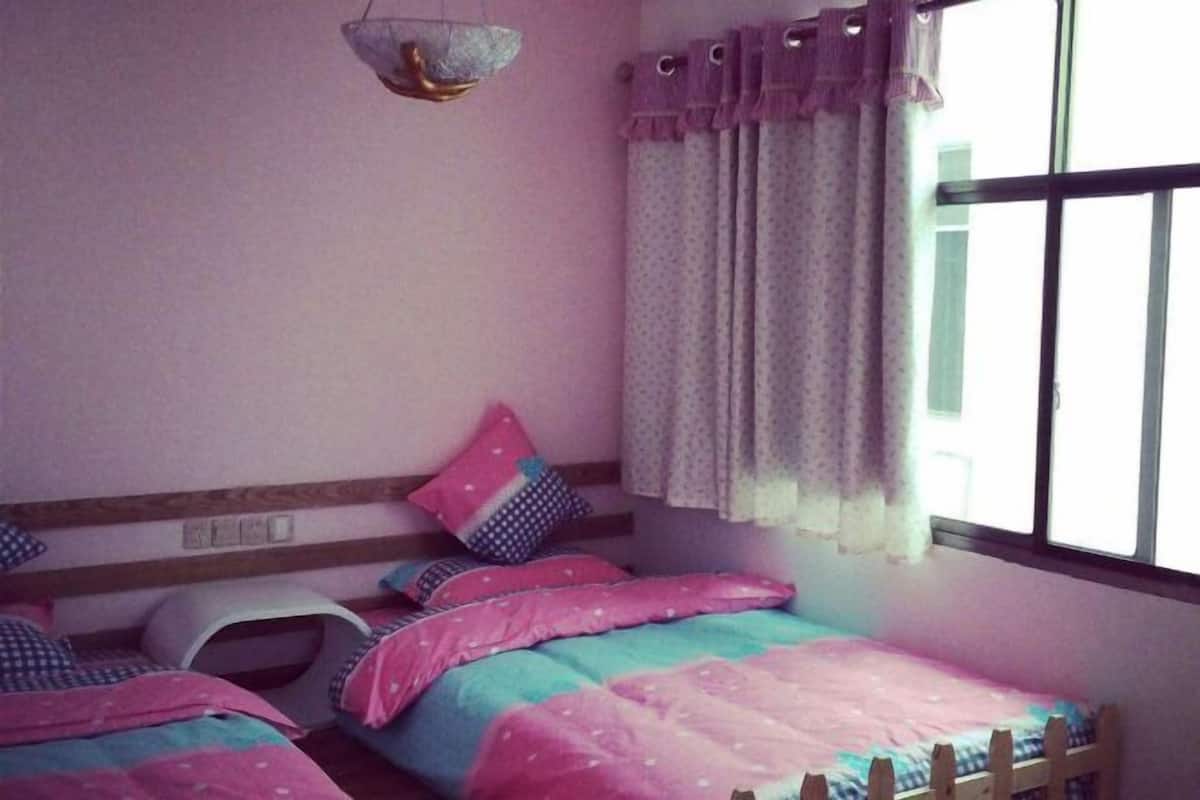 Ein Schlafzimmer mit Etagenbett, Nachttisch, einer Pendelleuchte und einem Fenster mit Vorhängen.