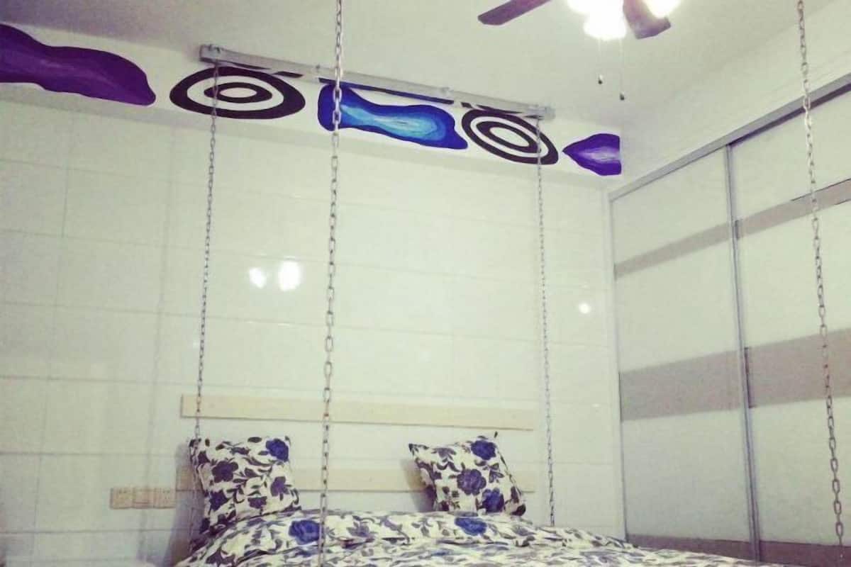 Ein Schlafzimmer mit einem Bett, einem Deckenventilator und einem Fenster.