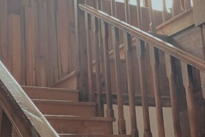 Un escalier en bois, doté d’une rampe, menant à un niveau supérieur.