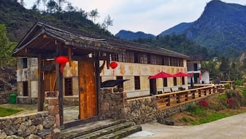 A traditional building with a stone foundation, wooden beams, and a red awning.