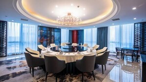 Un coin repas avec une table ronde, des chaises et un lustre.
