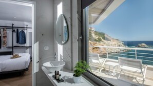A modern bathroom with a large window, a white sink, and a potted plant. - Made By The Sea Villas 12 Bdrm (Malevizi)