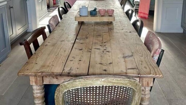 A dining area with a wooden table, chairs, and a central serving tray.